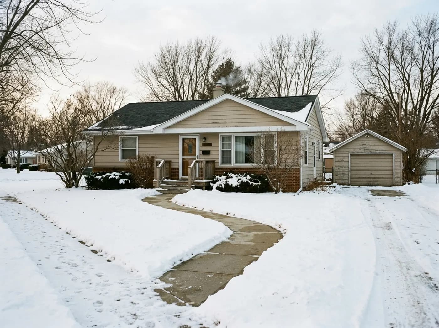 A modest older single-story home in Stillman Valley, Illinois with a shoveled front walkway